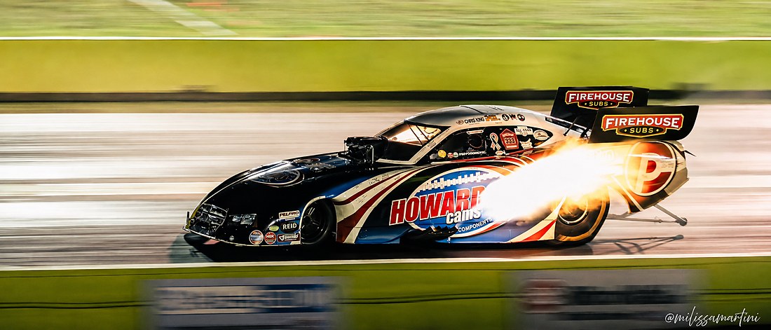 Chris King Racing nitro Funny Car at speed, header flames lit